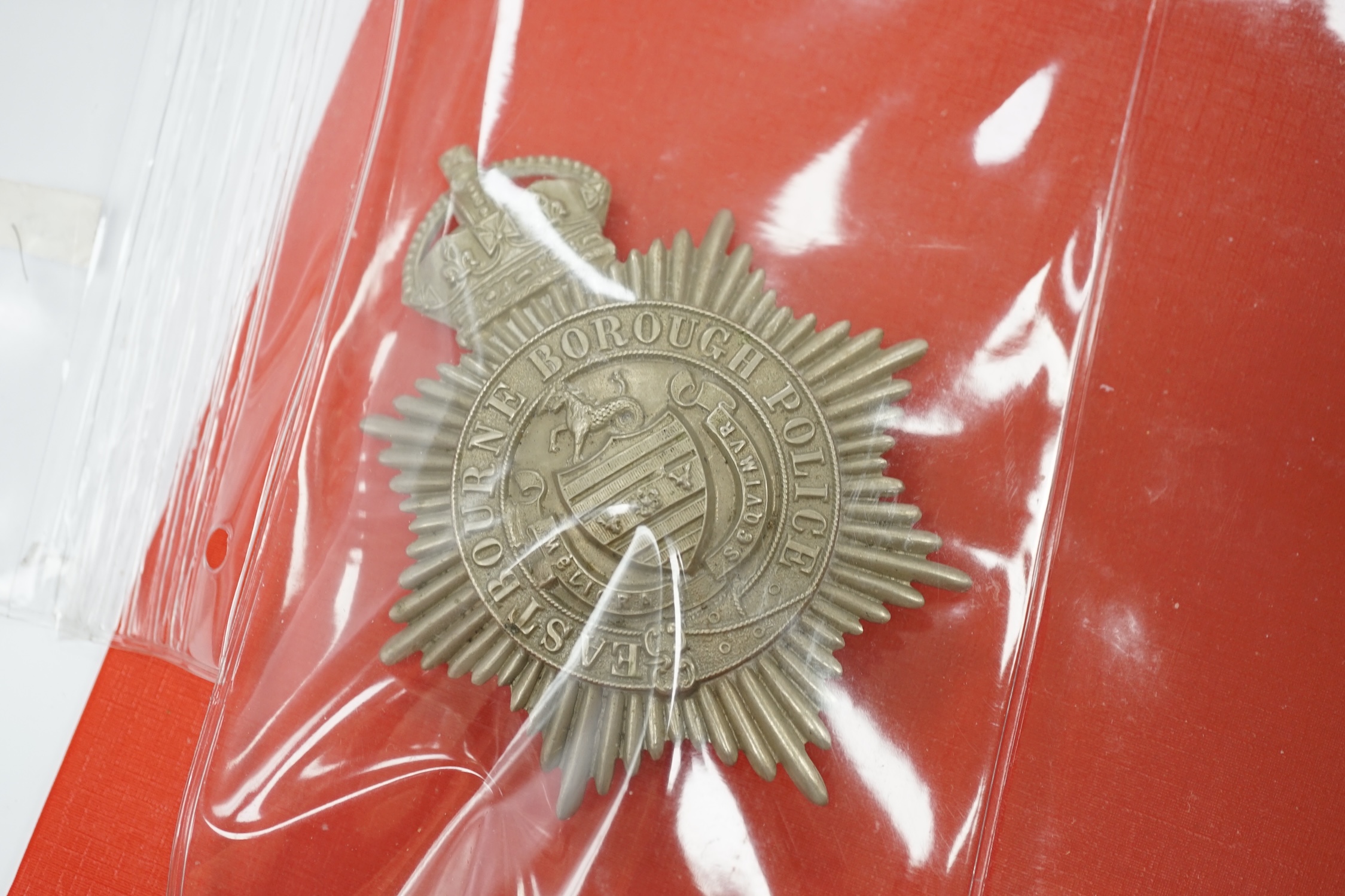 A collection of Police badges and buttons, including to Eastbourne Borough Police helmet plates, Eastbourne Fire Brigade uniform buttons, Royal Navy buttons, a whistle, etc. together with a batten decorated with beadwork